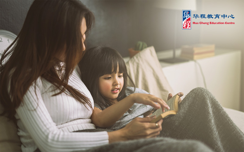 Mother and Daughter Reading Book at Home in the Bedroom