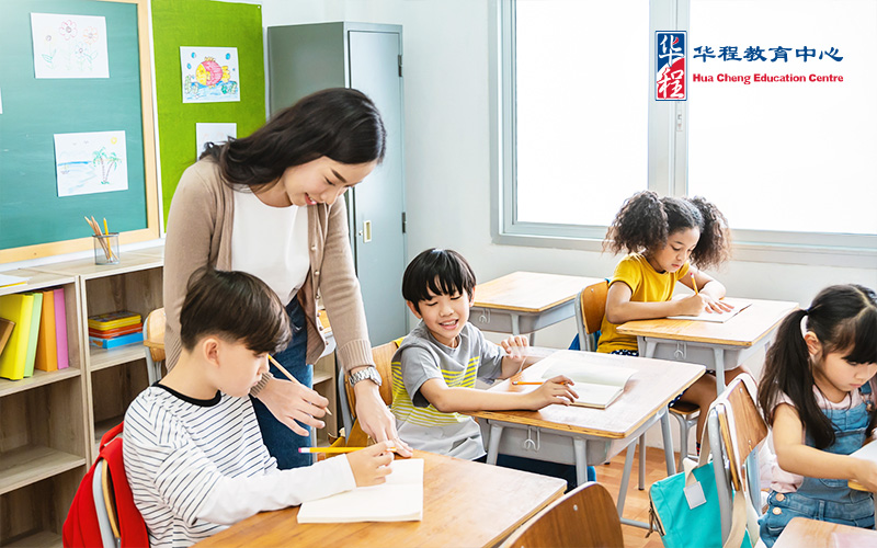 Pupil With Teacher In Classroom At Elementary School