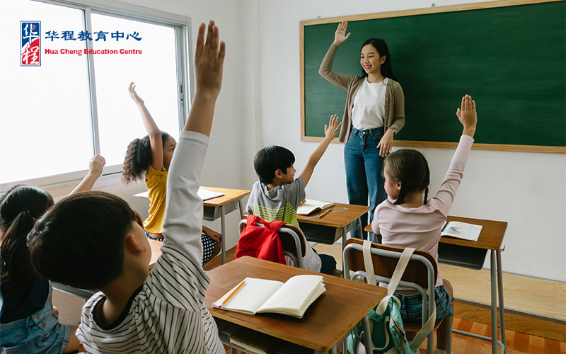 Students and teacher raising their hands in class